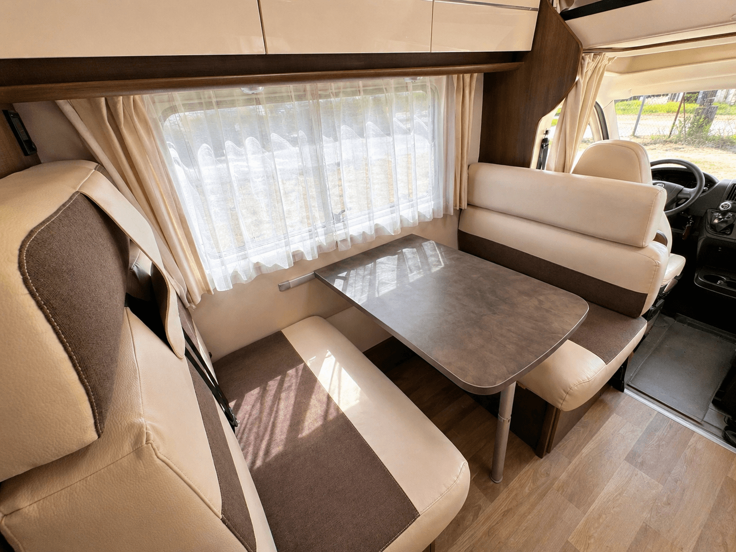 Heller Essbereich im Wohnmobil mit Sitzplaetzen rund um den Tisch
