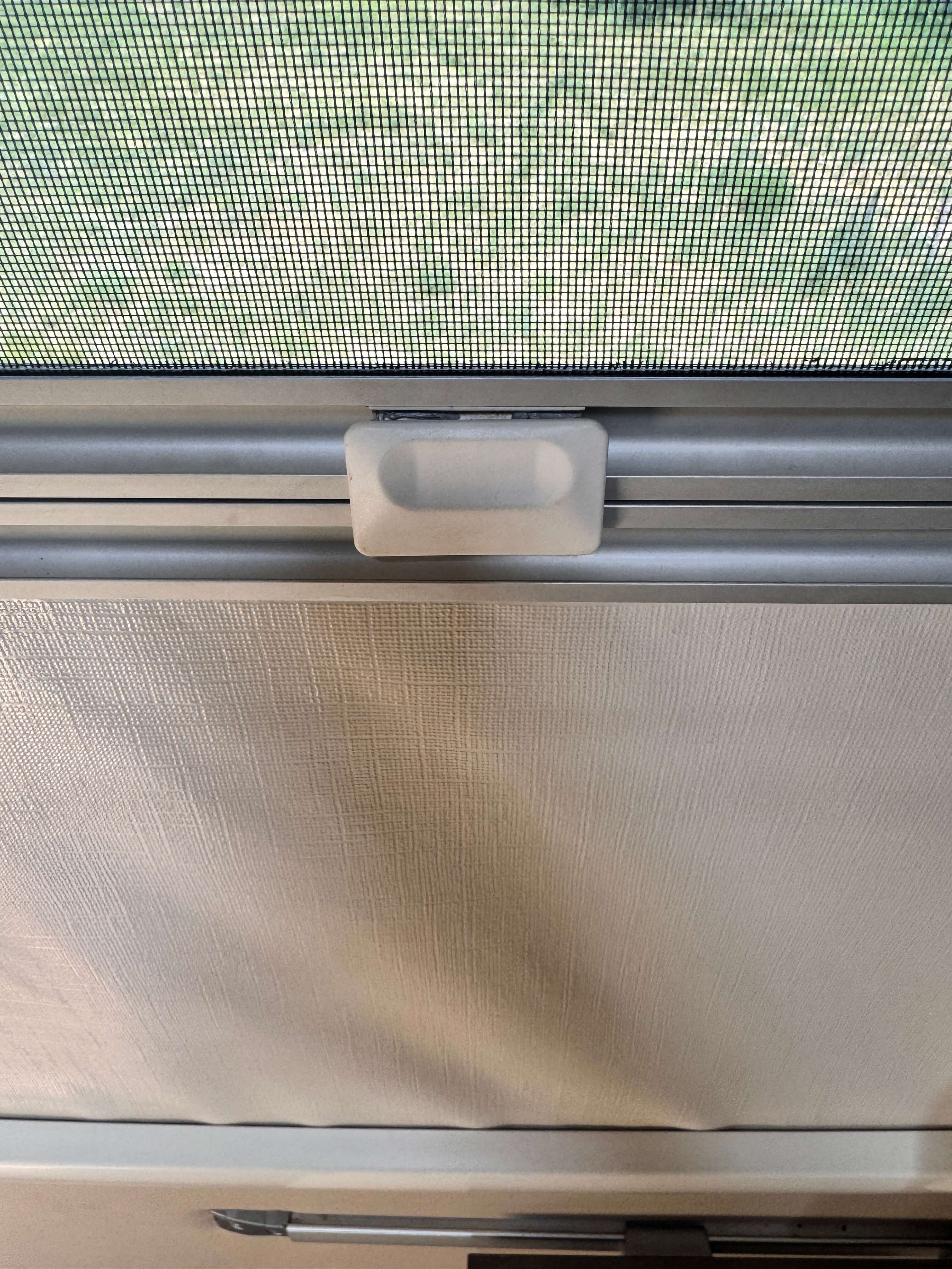 Ablak napellenzője és szúnyoghálója a középső rögzítő műanyaggal